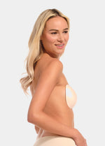 Woman wearing a beige strapless Backless Beauty against a plain background