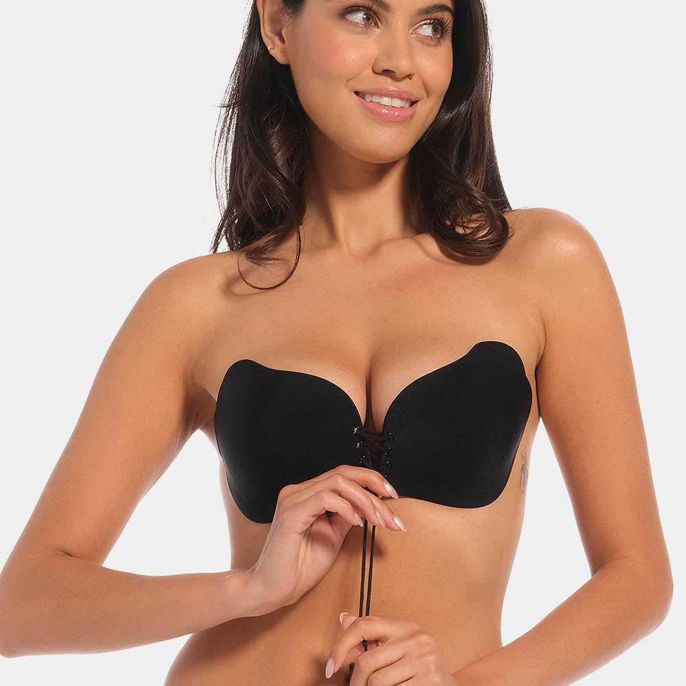 A woman wearing a black, backless, strapless adhesive bra with a drawstring front closure.
