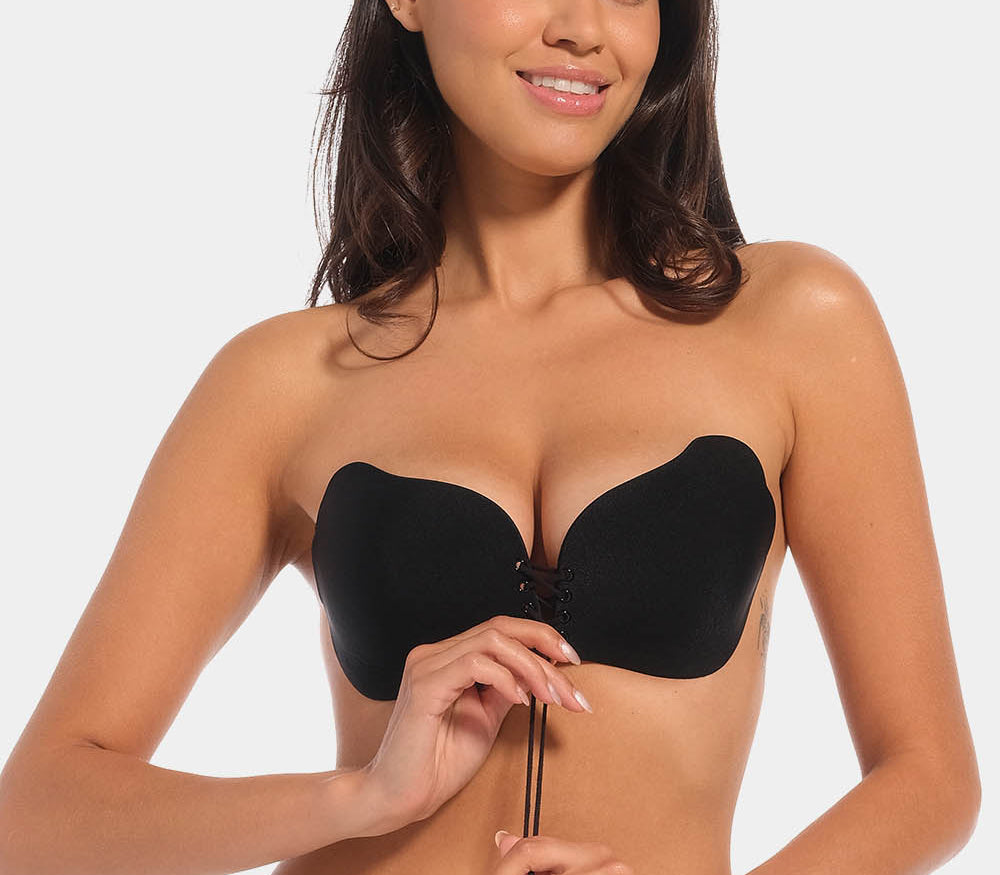 A woman wearing a black, backless, strapless adhesive bra with a drawstring front closure.