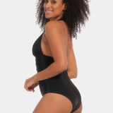 Woman wearing a black swimsuit with a plain background