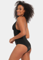 Woman wearing a black swimsuit with a plain background