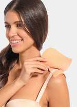 Woman wearing a beige shoulderpad against a light gray background